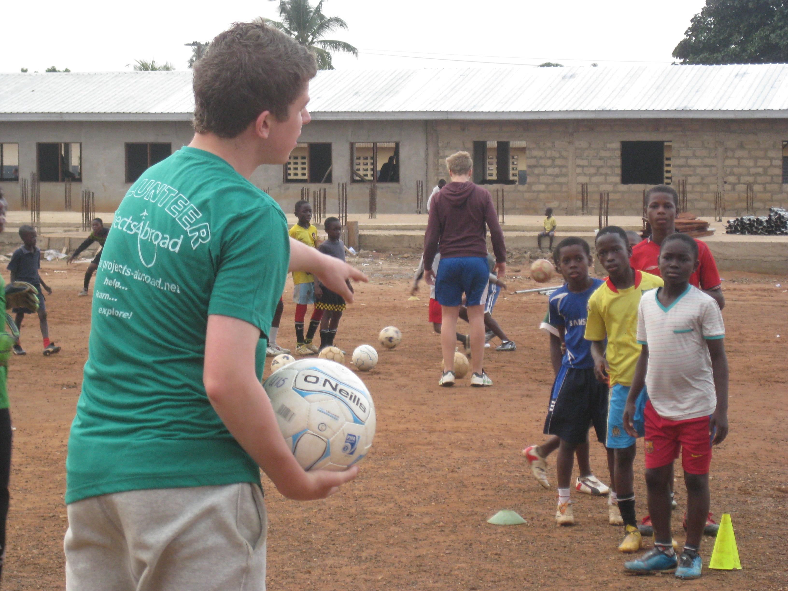 Children practise drills with their volunteer football coach in Ghana A football team practises drills during Projects Abroad's volunteer football coaching project in Ghana